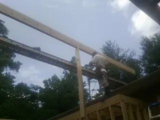 Carpenter setting a ridge beam over a new addition frame — Ice Dam Removal by Roofing Brothers in Hague