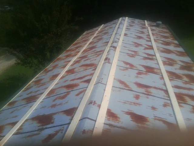Rusted metal roof panels with new wood purlins before replacement — Storm Damage Roof Repair in Hague by Roofing Brothers
