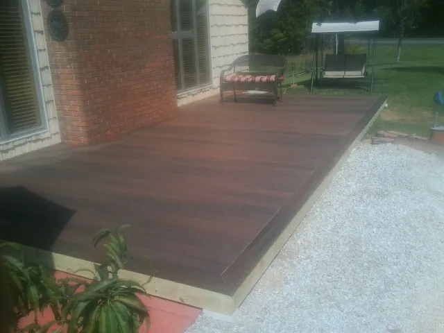 Freshly stained wood deck built against a brick home in Hague